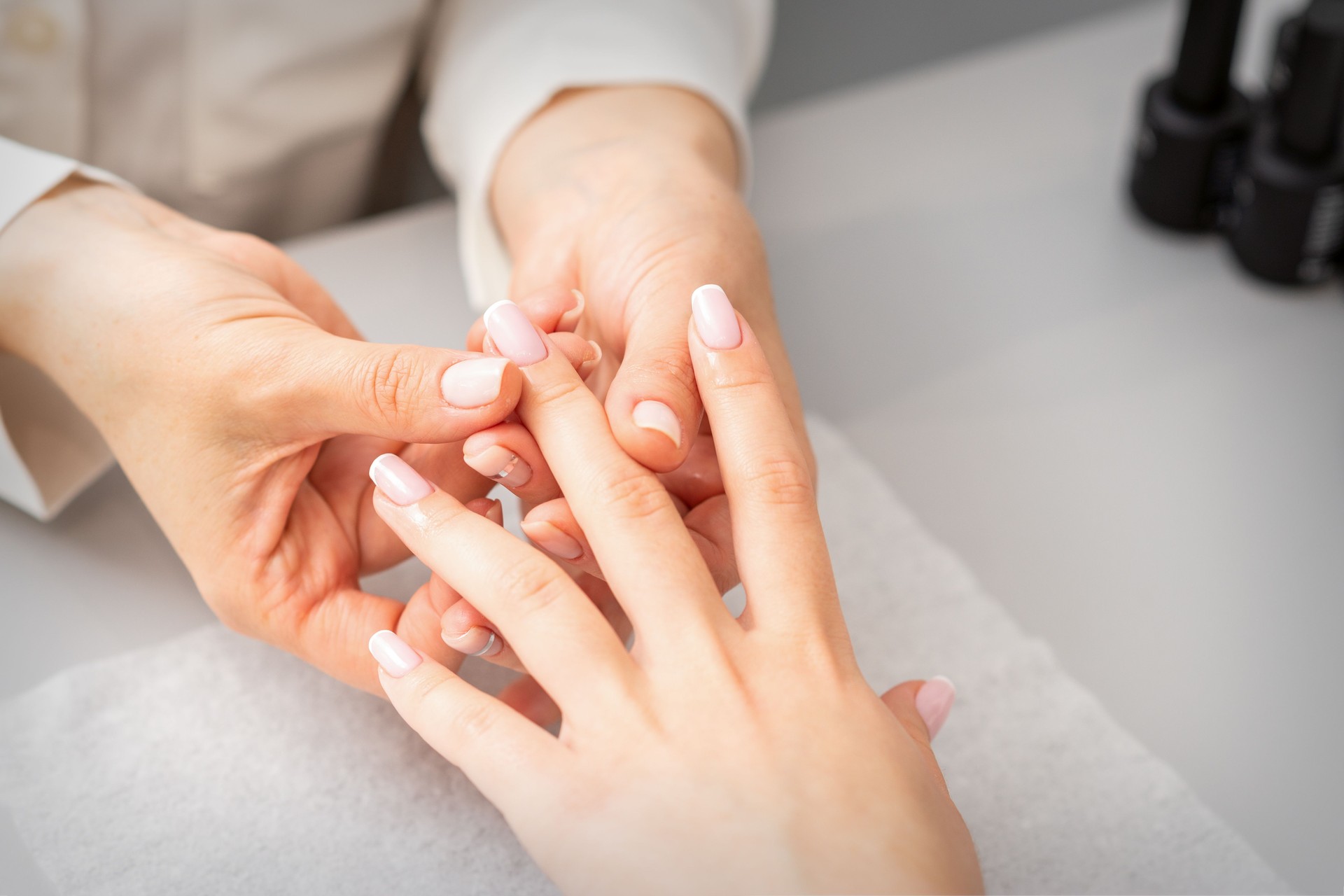 Manicure treatment at beauty spa. A hand of a woman getting a finger massage with oil in a nail salon.
